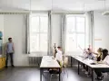 Nauczyciel pyta, ile trzeba mieć frekwencji żeby zdać. Uczniowie podnoszą ręce, gotowi do odpowiedzi.