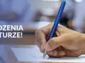 Dłoń pisze długopisem na arkuszu egzaminacyjnym. Napis "Powodzenia na maturze!" sugeruje, że to ważny moment dla osób z wykształceniem średnim.