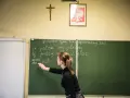 Nauczycielka tłumaczy odmianę czasownika "być" na lekcji. Zastanawiasz się, ile zarabia nauczyciel na godzinę? To zależy od wielu czynników.