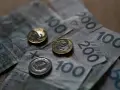 Złotówki na stole. Czy umowa zlecenie wlicza się do emerytury? Pieniądze i monety symbolizują przyszłość.