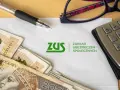 Pieniądze, długopis, okulary i kalkulator leżą obok dokumentu z logo ZUS. To może być podstawa do rozliczeń w systemie erp-7.