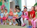 Uśmiechnięte dzieci siedzą w przedszkolu. Od ilu lat można tu uczęszczać?