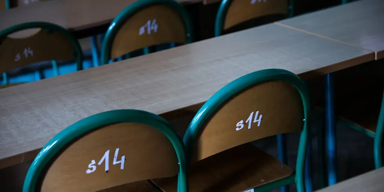 Puste ławki szkolne z numerami "s14" sugerują odwołane lekcje w szkołach 2026.