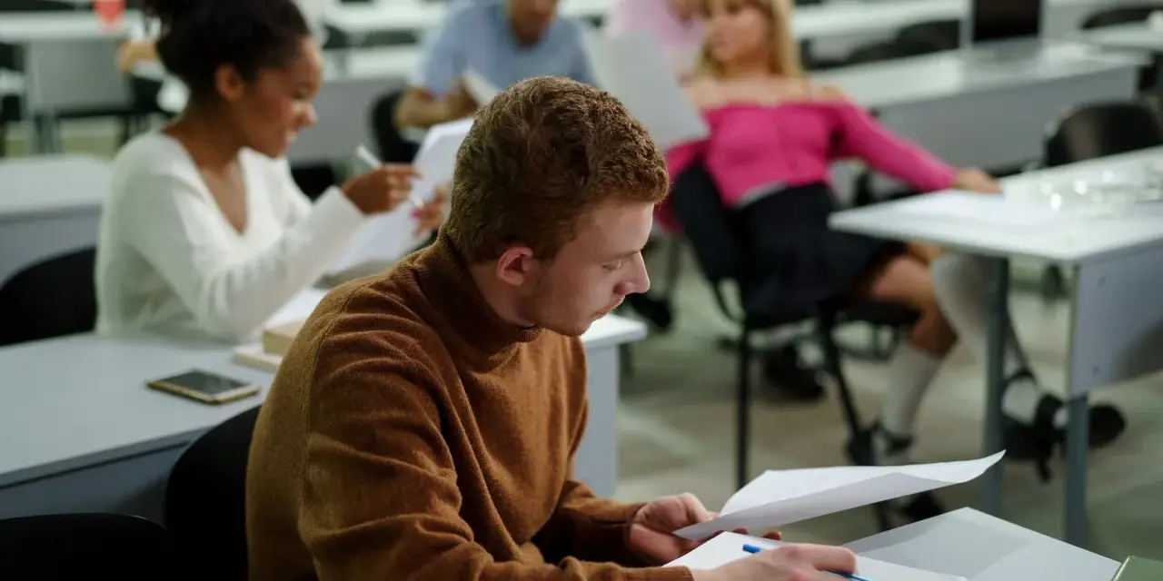 Studenci w sali wykładowej, skupieni na nauce. To dowód, że studia bez matury są możliwe i dają szansę na rozwój.