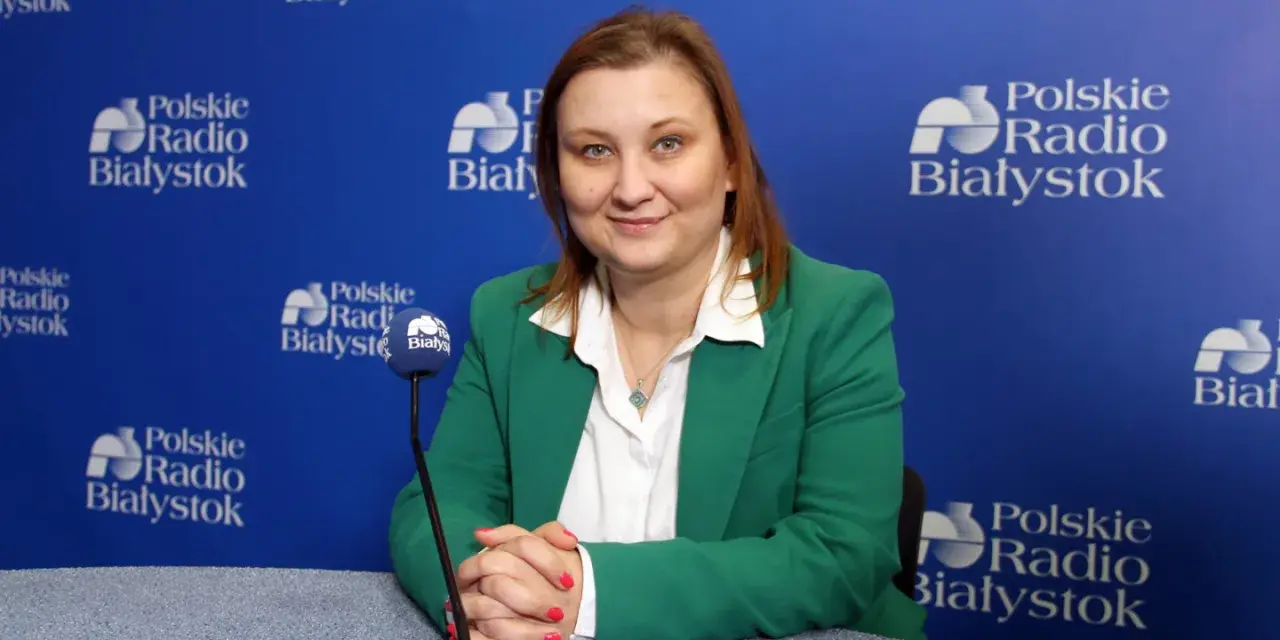 Wiceminister edukacji w zielonej marynarce udziela wywiadu w Polskim Radiu Białystok.