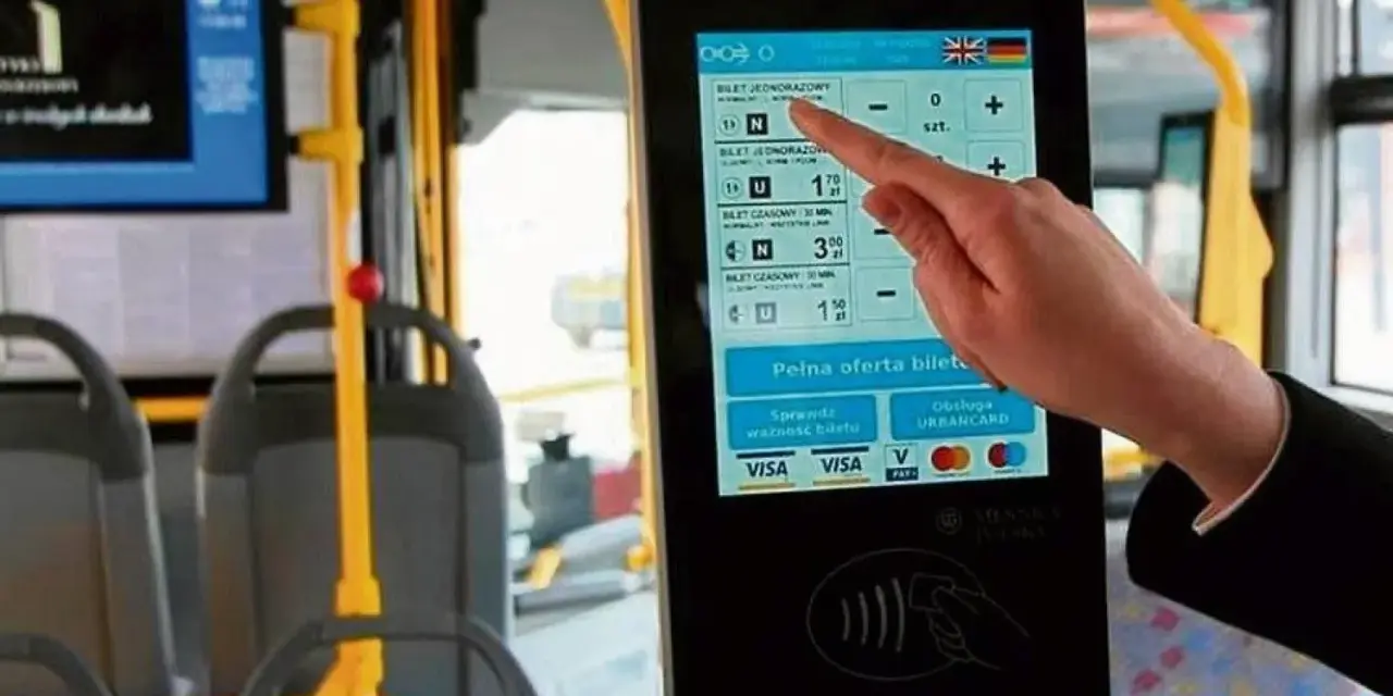 Ręka dotyka ekranu automatu biletowego w autobusie. Czy we Wrocławiu uczniowie jeżdżą za darmo? Tu kupisz bilet, sprawdzisz jego ważność i zapłacisz kartą.