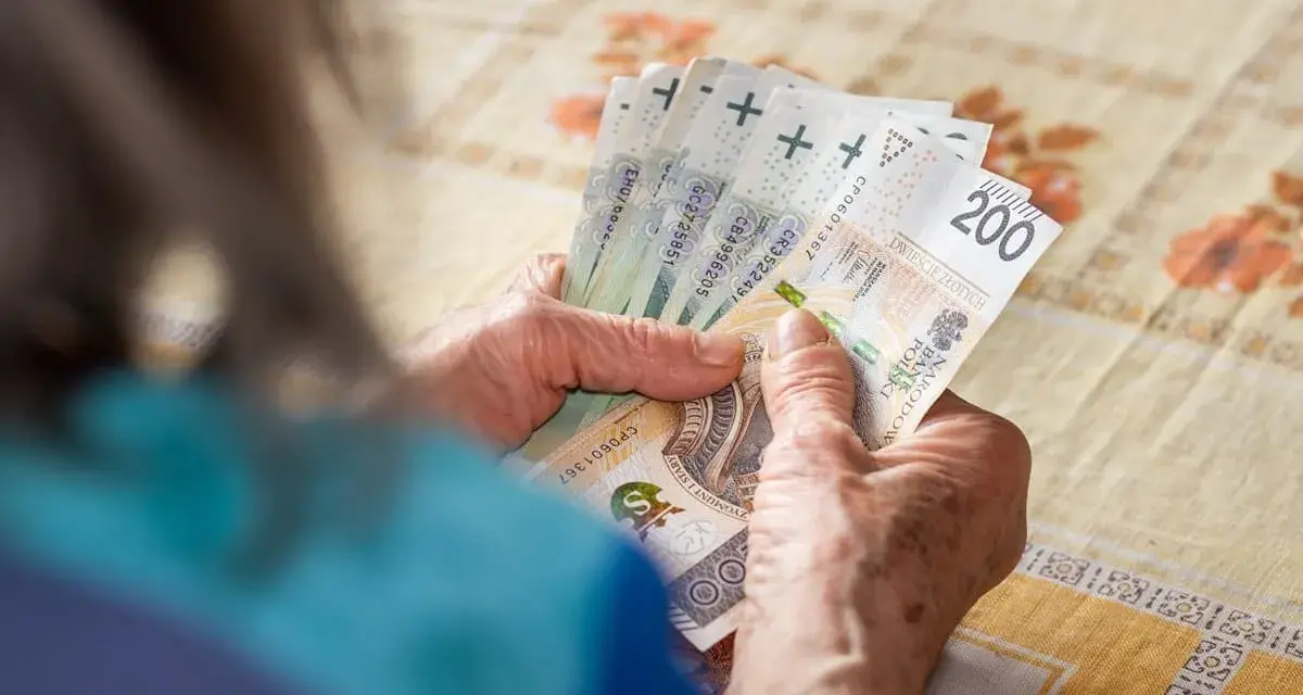 Dłonie liczą banknoty 200 zł. Zastanawiasz się, ile trzeba przepracować na 13 pensję?