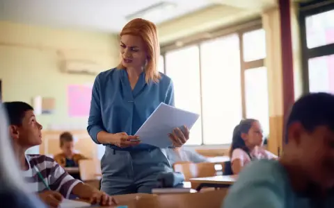 Nauczycielka omawia projekt oceny dorobku zawodowego z uczniami w klasie.