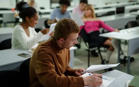 Studenci w sali wykładowej, skupieni na nauce. To dowód, że studia bez matury są możliwe i dają szansę na rozwój.