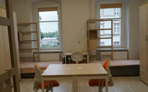 Pokój studencki, gdzie bursa co to? Dwa łóżka, biurka, szafy i regały.