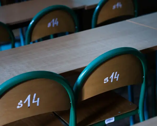 Puste ławki szkolne z numerami "s14" sugerują odwołane lekcje w szkołach 2026.