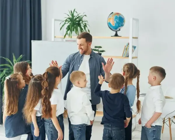 Nauczyciel z dziećmi świętuje koniec semestru. Wesoła klasa, która czeka na wystawienie ocen na 1 semestr.
