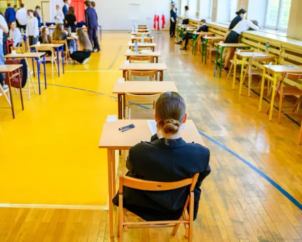 Uczniowie siedzą w ławkach, przygotowując się do egzaminu maturalnego. Atmosfera skupienia towarzyszy przyszłym maturzystom w drodze do matury 2026.
