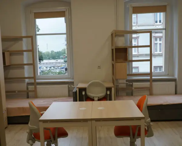 Pokój studencki, gdzie bursa co to? Dwa łóżka, biurka, szafy i regały.