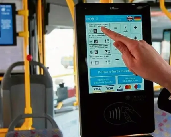 Ręka dotyka ekranu automatu biletowego w autobusie. Czy we Wrocławiu uczniowie jeżdżą za darmo? Tu kupisz bilet, sprawdzisz jego ważność i zapłacisz kartą.
