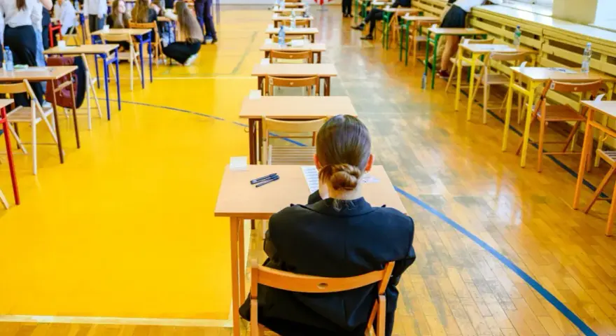 Uczniowie siedzą w ławkach, przygotowując się do egzaminu maturalnego. Atmosfera skupienia towarzyszy przyszłym maturzystom w drodze do matury 2026.
