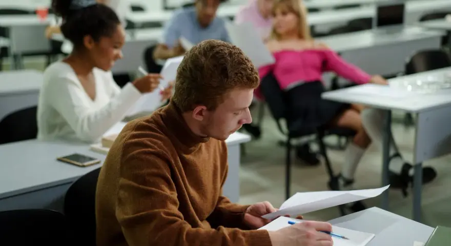 Studenci w sali wykładowej, skupieni na nauce. To dowód, że studia bez matury są możliwe i dają szansę na rozwój.