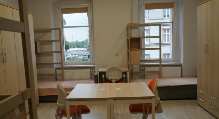 Pokój studencki, gdzie bursa co to? Dwa łóżka, biurka, szafy i regały.