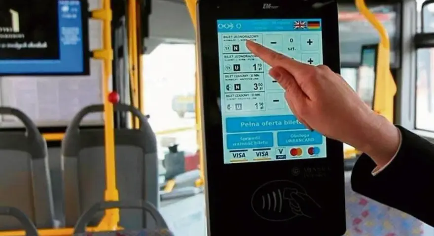 Ręka dotyka ekranu automatu biletowego w autobusie. Czy we Wrocławiu uczniowie jeżdżą za darmo? Tu kupisz bilet, sprawdzisz jego ważność i zapłacisz kartą.