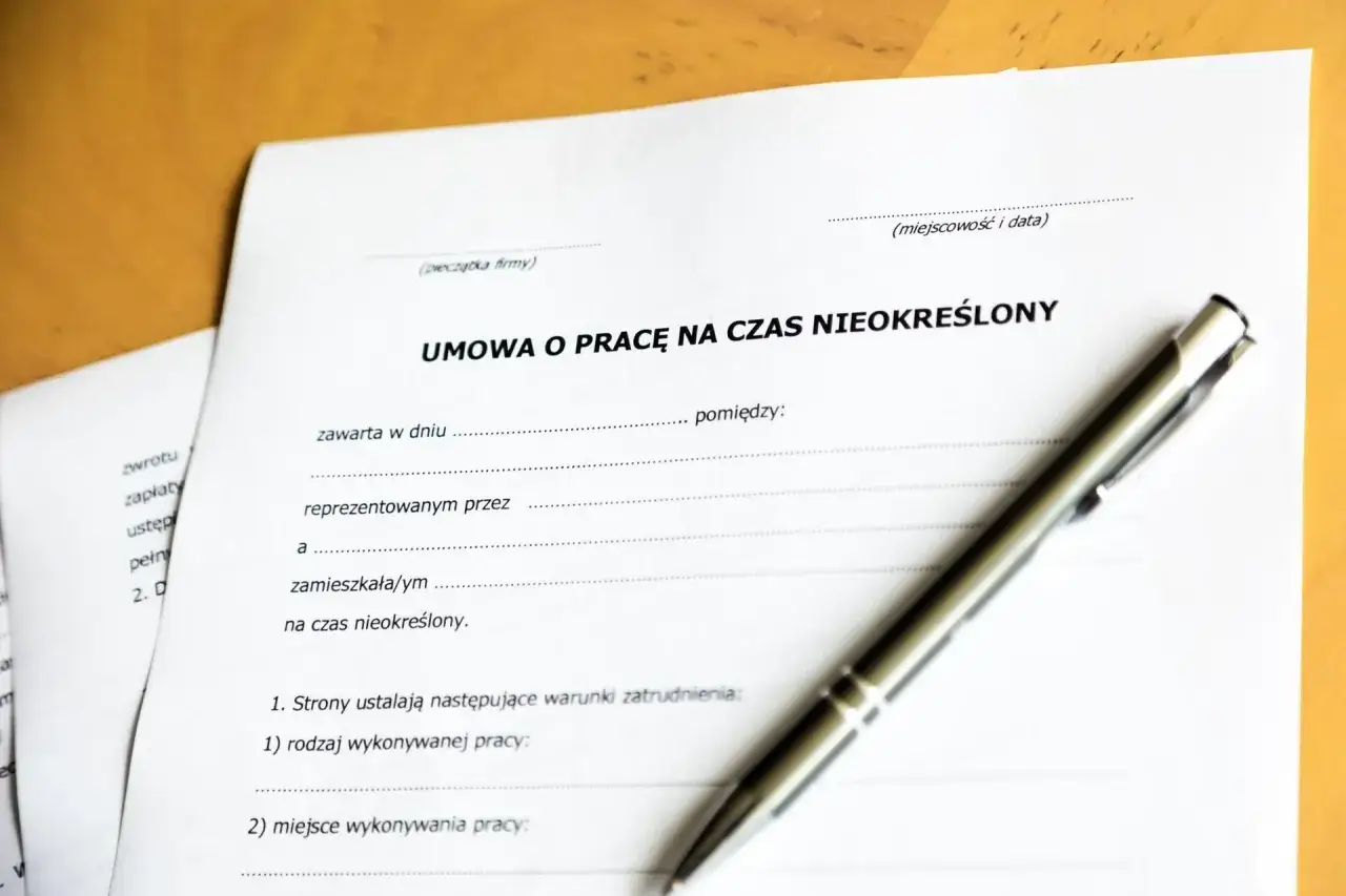 Umowa o pracę na czas nieokreślony, dokument potwierdzający porozumienie stron, leży obok długopisu.