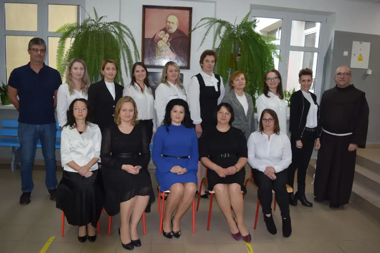 Grupa nauczycieli pozuje do zdjęcia. To ważna rada pedagogiczna, która wspólnie pracuje nad rozwojem uczniów.