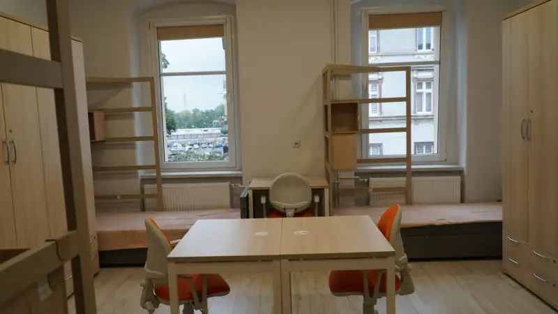 Pokój studencki, gdzie bursa co to? Dwa łóżka, biurka, szafy i regały.